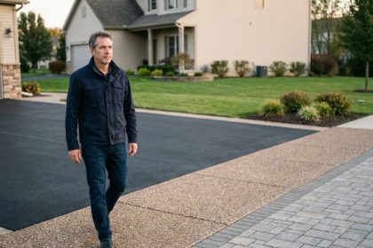 Homme en jeans et veste marche dans une all&eacute;e r&eacute;nov&eacute;e